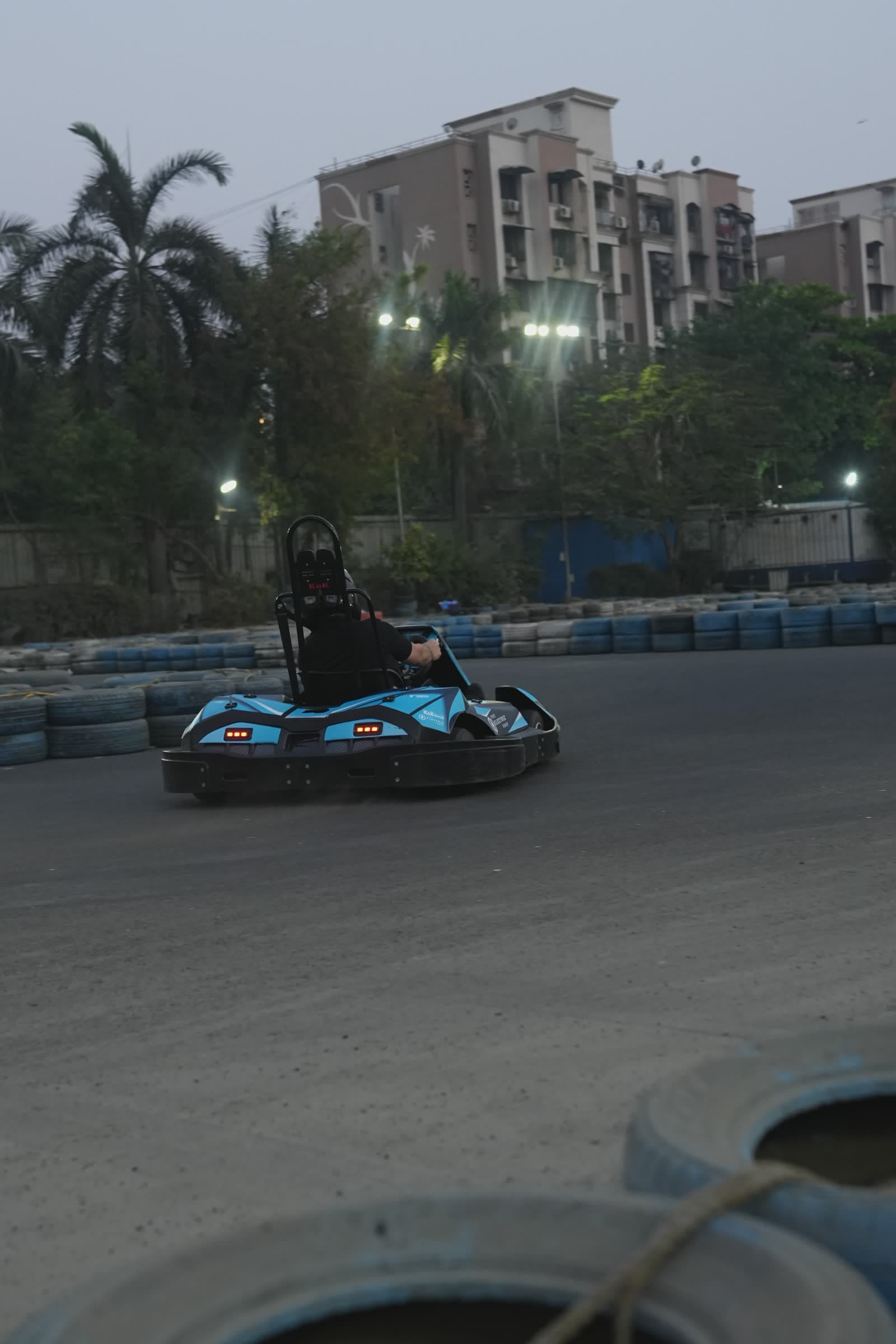 Electric karts racing at dusk with taillights glowing